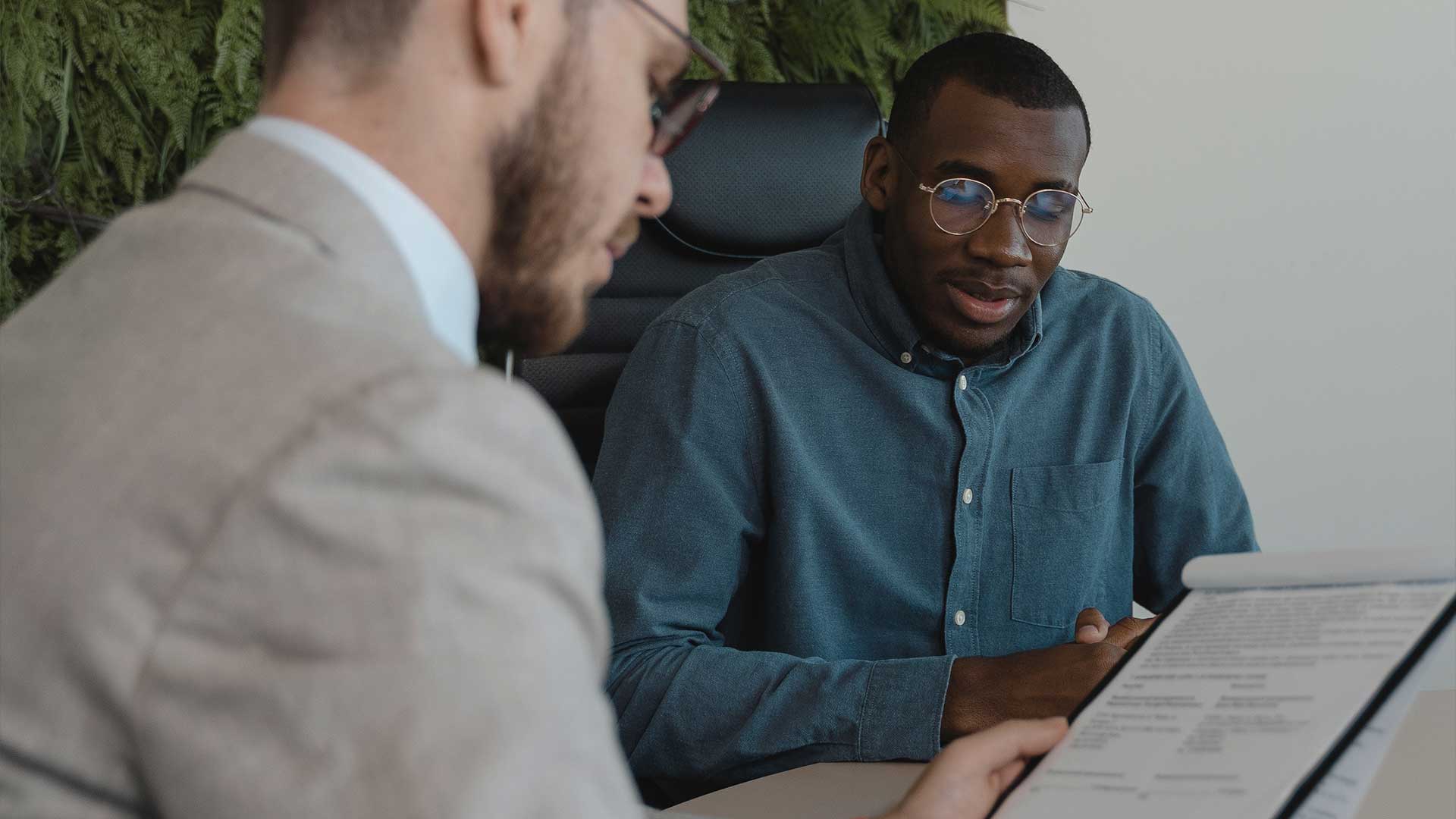 A staff member talking to a student over a notepad
