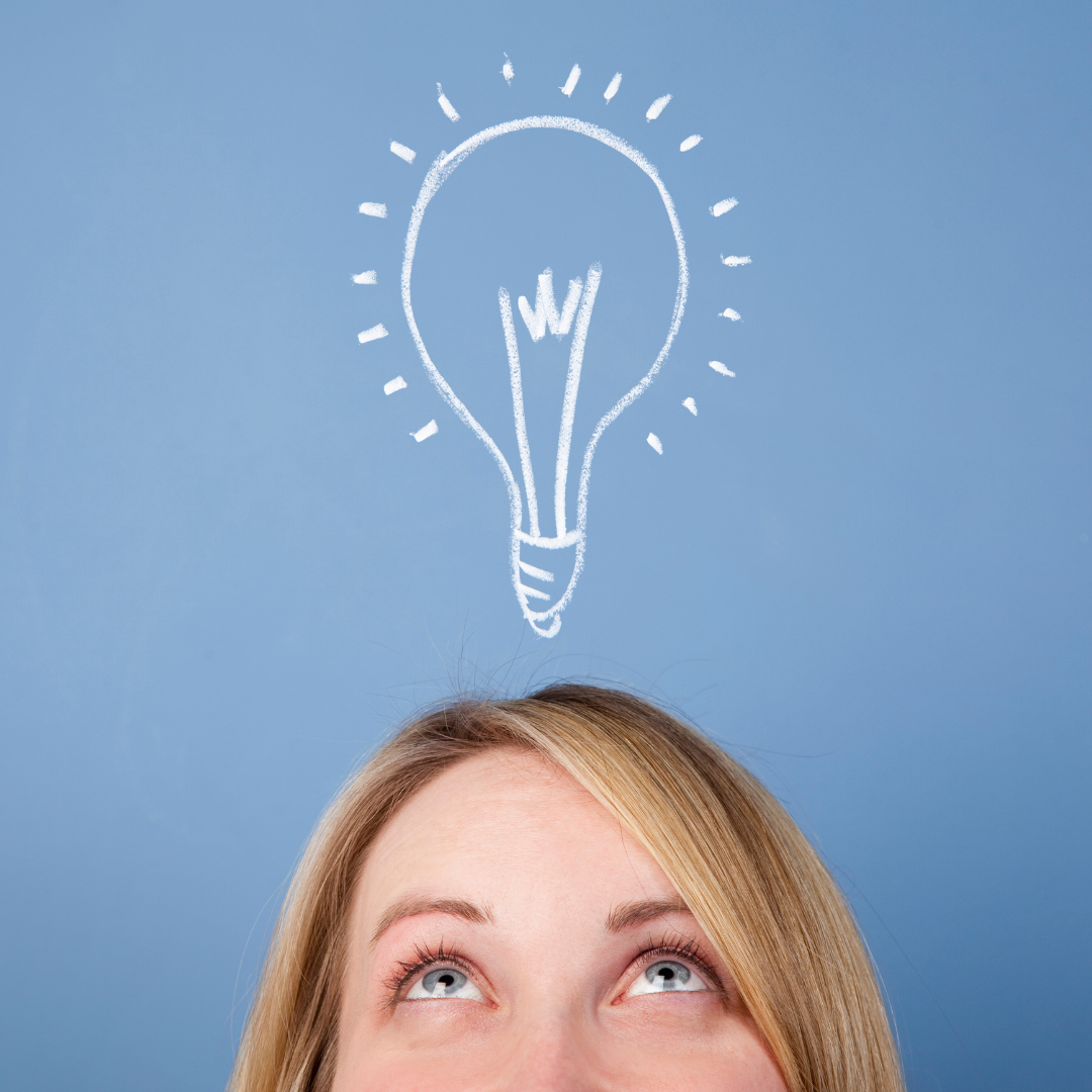 The top of a Caucasian persons head looking up at an illustration of a light bulb against a blue background