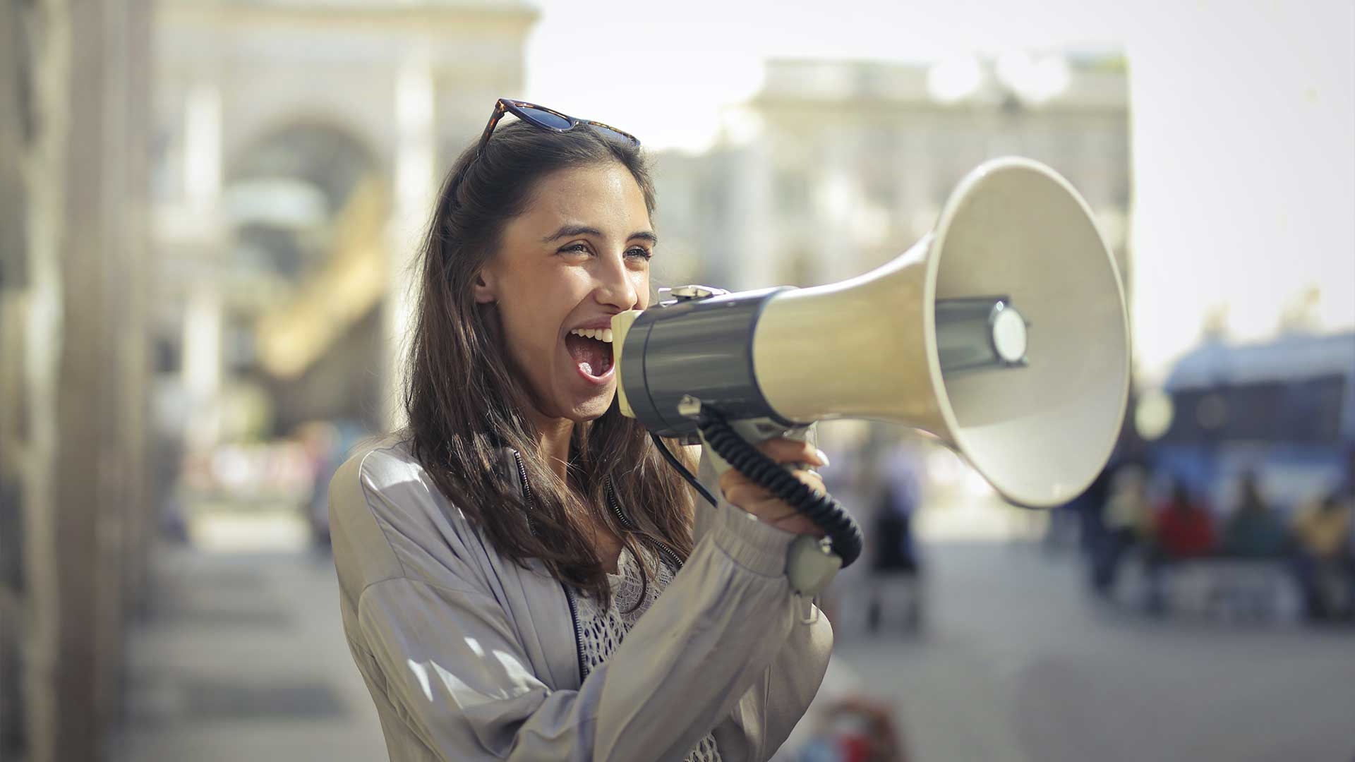 A student talking into a megaphone and smiling