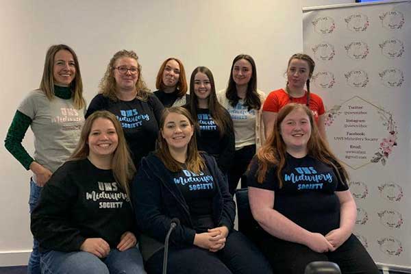 9 members of the UWS Midwifery Society smiling at the camera